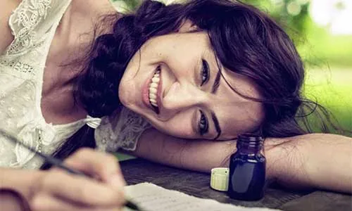 Mujer sonriente y relajada, recostada con la cabeza sobre los brazos