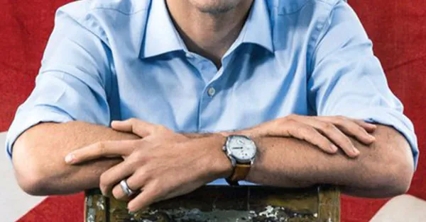 Detalle de los brazos cruzados de Trudeau sobre el respaldo de la silla