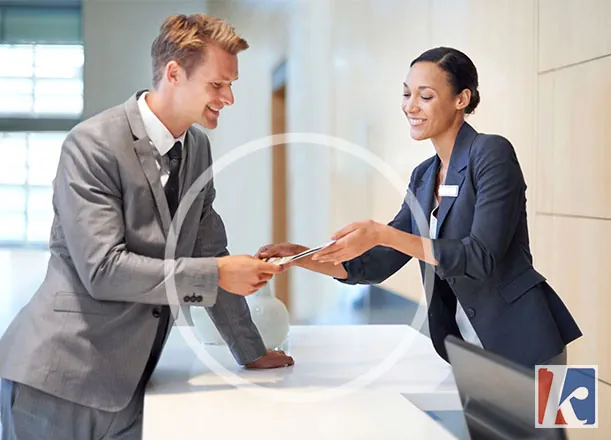 Recepcionista entregando un objeto al huésped con una ligera inclinación